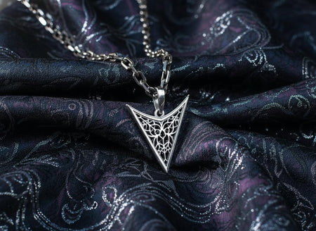 A detailed studio shot of an inverted triangle-shaped pendant hanging from a sturdy chain. The design features a "V" shape frame filled with complex, organic filigree. The inner pattern resembles branching roots, veins, or the "Flamboyant" style of late Gothic window tracery. The raised silver lines are polished bright, contrasting with the matte black oxidation in the negative spaces. (etsy image id: 7496362357)