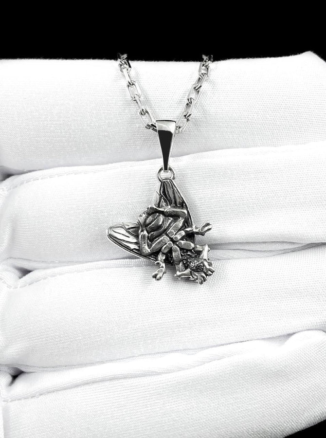 May include: A silver-colored pendant necklace featuring a detailed insect design. The pendant depicts a cicada with intricate wing and body details, suspended from a delicate chain. The necklace is displayed against a white background.