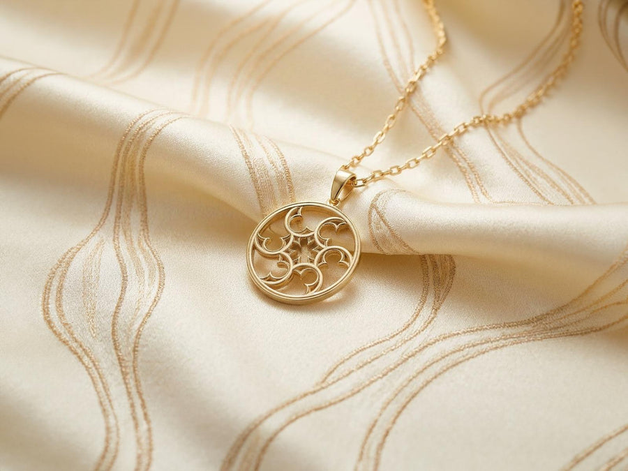 A detailed close-up of a circular sterling silver pendant resting on a dark blue, textured silk fabric. The pendant features an openwork design with swirling, crescent-like shapes radiating from a central four-pointed star. The intricate pattern resembles a gothic rose window or a celestial wheel. The raised metal surfaces are polished to a bright silver shine, contrasting beautifully against the dark, oxidized background recesses. (etsy image id: 7830974908)