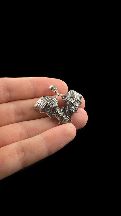 Featuring a detailed bat with outstretched wings, our unique design is sure to stand out. Don't let the darkness keep you down—power up your style with a silver bat pendant today! (etsy image id: 6086867201)