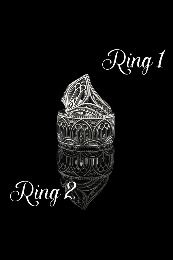 A high-resolution macro shot of a wide sterling silver wedding band resting on a sparkling, icy white surface. The ring features an intricate openwork design mimicking a Gothic cathedral window, complete with pointed lancet arches and delicate stone tracery. The polished silver highlights contrast beautifully against the dark, oxidized background, emphasizing the architectural depth of the piece.