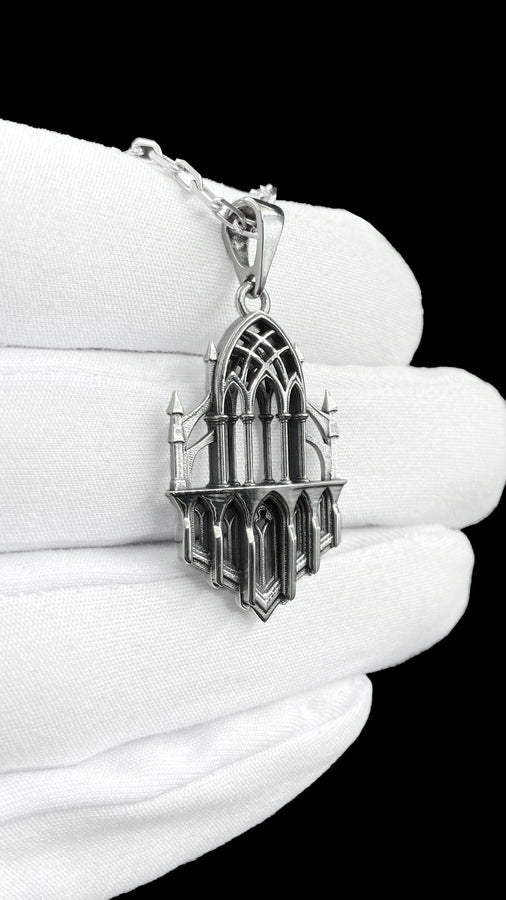 This macro image highlights the masterful craftsmanship of the solid 925 sterling silver casting. The artisan has flawlessly translated monumental stone architecture into miniature metalwork. The columns are smooth and precise, while deep sulfur oxidation creates a permanent matte black shadow in the open recesses of the arches. This traditional antiquing technique gives the gothic relic pendant the weathered, enduring texture of an actual historical cathedral fragment. (etsy image id: 7979026828)