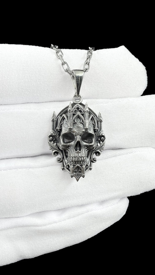 This macro image highlights the masterful texturing of the solid 925 sterling silver casting. The artisan has beautifully captured the smooth, anatomical curves of the organic skull, contrasting them against the rigid, geometric lines of the gothic tracery and cathedral spires. A deep sulfur patina treatment provides permanent matte black shadows, giving this wearable sculpture the rugged, weathered patina of a genuine historical artifact. (etsy image id: 7979410208)