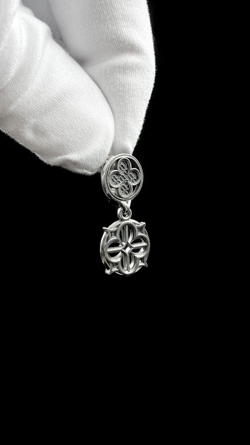 The image highlights the specific textures of the casting. The top stud has a "waffle" or lattice texture inside the quatrefoil lobes, mimicking chainmail or stone carving. The bottom drop is smooth and open, providing a visual counterweight. The 925 sterling silver is treated with an antique patina to enhance the "old world" feel. Modeled as a versatile daily earring, the "coin" size is modest enough for office wear (etsy image id: 5775868859)
