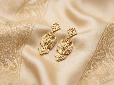 Reimagined in solid 14k yellow gold, these seraphim halo earrings transform from a brooding gothic artifact into a radiant, celestial treasure. The warm golden metal makes the angel figure glow like a sunlit Renaissance sculpture, while the intricate feathers and halo gleam with opulent luxury. A soft, brushed matte finish replaces the dark oxidation in the recesses, elevating this protective talisman into a magnificent masterpiece. (etsy image id: 8003026944)