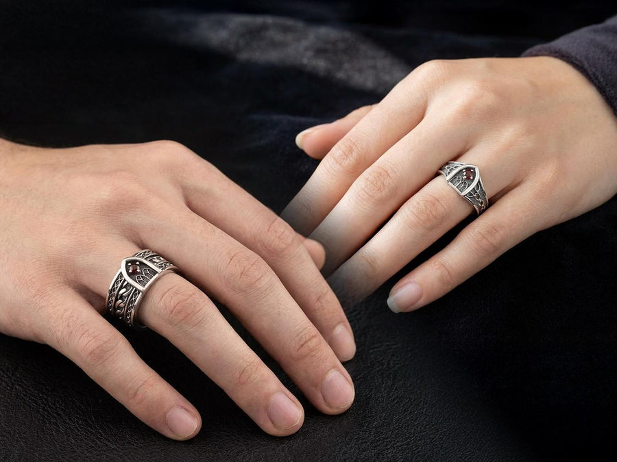 A professional studio photograph of a matching two-piece sterling silver wedding ring set. Both rings feature a prominent, raised Greek-style cross motif in the center, which holds a round, bezel-set white crystal. The interior of the cross arms has a fine, cross-hatched grid texture. Along the sides of the high-polished silver bands are recessed, four-lobed quatrefoil shapes. The rings are presented against a pitch-black background, making the p __etsy:8051335185