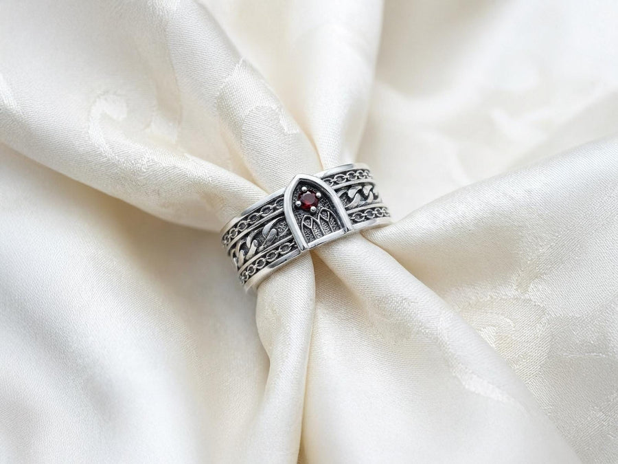 A professional studio photograph of a matching two-piece sterling silver wedding ring set. Both rings feature a prominent, raised Greek-style cross motif in the center, which holds a round, bezel-set white crystal. The interior of the cross arms has a fine, cross-hatched grid texture. Along the sides of the high-polished silver bands are recessed, four-lobed quatrefoil shapes. The rings are presented against a pitch-black background, making the p __etsy:8051335185