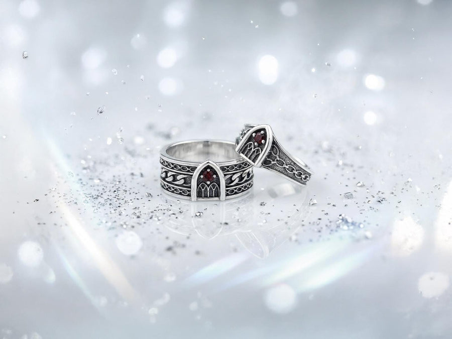 A professional studio photograph of a matching two-piece sterling silver wedding ring set. Both rings feature a prominent, raised Greek-style cross motif in the center, which holds a round, bezel-set white crystal. The interior of the cross arms has a fine, cross-hatched grid texture. Along the sides of the high-polished silver bands are recessed, four-lobed quatrefoil shapes. The rings are presented against a pitch-black background, making the p __etsy:8051335185