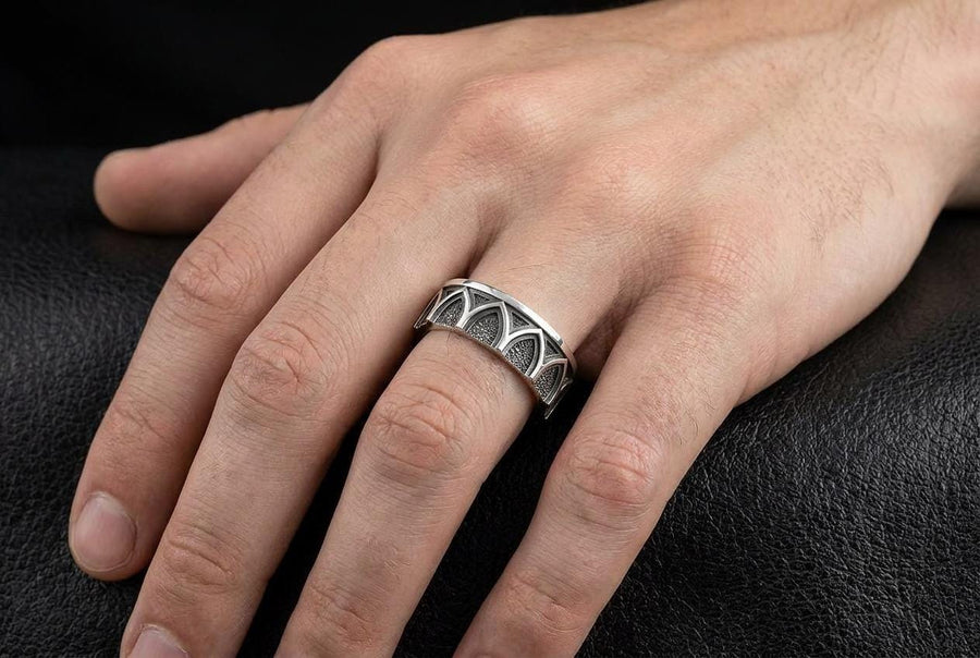 A professional studio photograph of a matching two-piece sterling silver wedding ring set. Both rings feature a prominent, raised Greek-style cross motif in the center, which holds a round, bezel-set white crystal. The interior of the cross arms has a fine, cross-hatched grid texture. Along the sides of the high-polished silver bands are recessed, four-lobed quatrefoil shapes. The rings are presented against a pitch-black background, making the p __etsy:8051335185