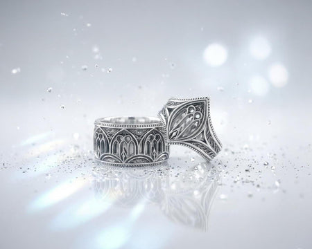 A high-resolution macro shot of a wide sterling silver wedding band resting on a sparkling, icy white surface. The ring features an intricate openwork design mimicking a Gothic cathedral window, complete with pointed lancet arches and delicate stone tracery. The polished silver highlights contrast beautifully against the dark, oxidized background, emphasizing the architectural depth of the piece.