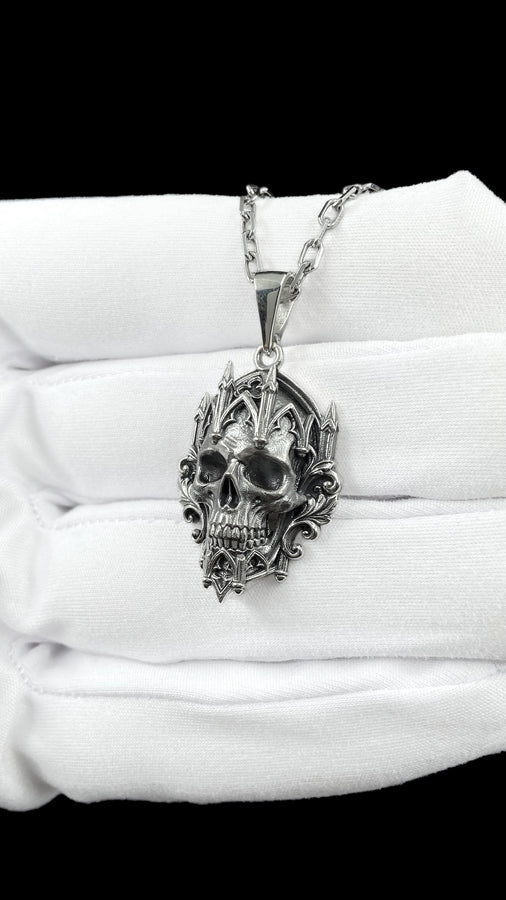 This macro image highlights the masterful texturing of the solid 925 sterling silver casting. The artisan has beautifully captured the smooth, anatomical curves of the organic skull, contrasting them against the rigid, geometric lines of the gothic tracery and cathedral spires. A deep sulfur patina treatment provides permanent matte black shadows, giving this wearable sculpture the rugged, weathered patina of a genuine historical artifact. (etsy image id: 7979410208)