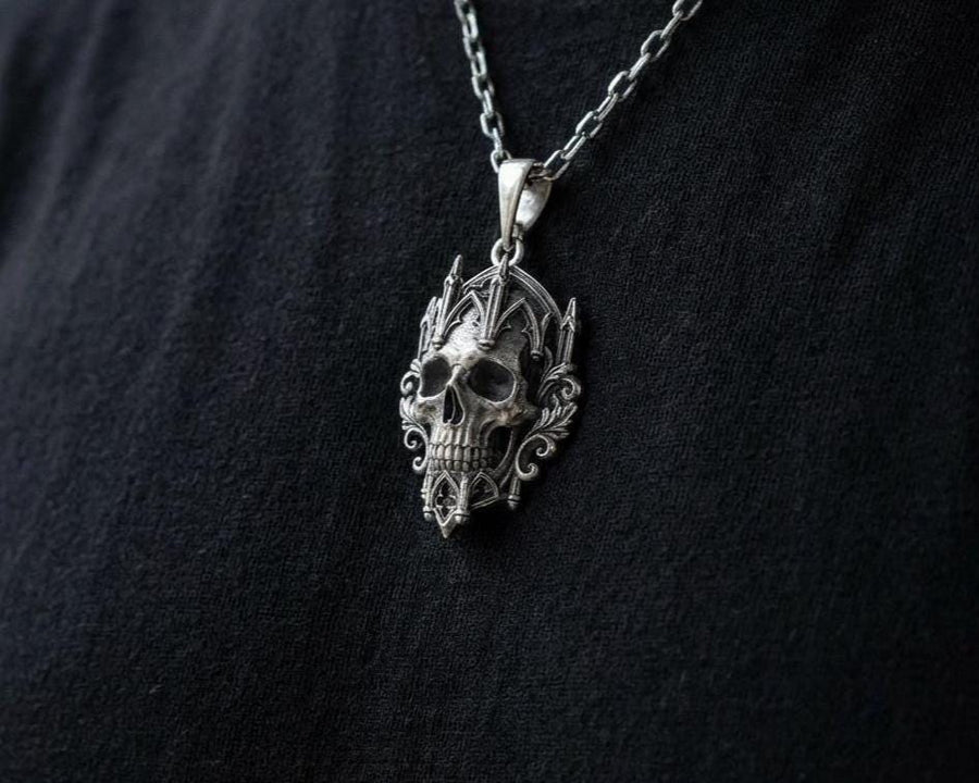 This macro image highlights the masterful texturing of the solid 925 sterling silver casting. The artisan has beautifully captured the smooth, anatomical curves of the organic skull, contrasting them against the rigid, geometric lines of the gothic tracery and cathedral spires. A deep sulfur patina treatment provides permanent matte black shadows, giving this wearable sculpture the rugged, weathered patina of a genuine historical artifact. (etsy image id: 7979410208)