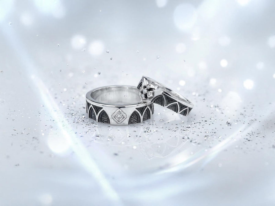 A professional studio photograph of a matching two-piece sterling silver wedding ring set. Both rings feature a prominent, raised Greek-style cross motif in the center, which holds a round, bezel-set white crystal. The interior of the cross arms has a fine, cross-hatched grid texture. Along the sides of the high-polished silver bands are recessed, four-lobed quatrefoil shapes. The rings are presented against a pitch-black background, making the p __etsy:8051335185