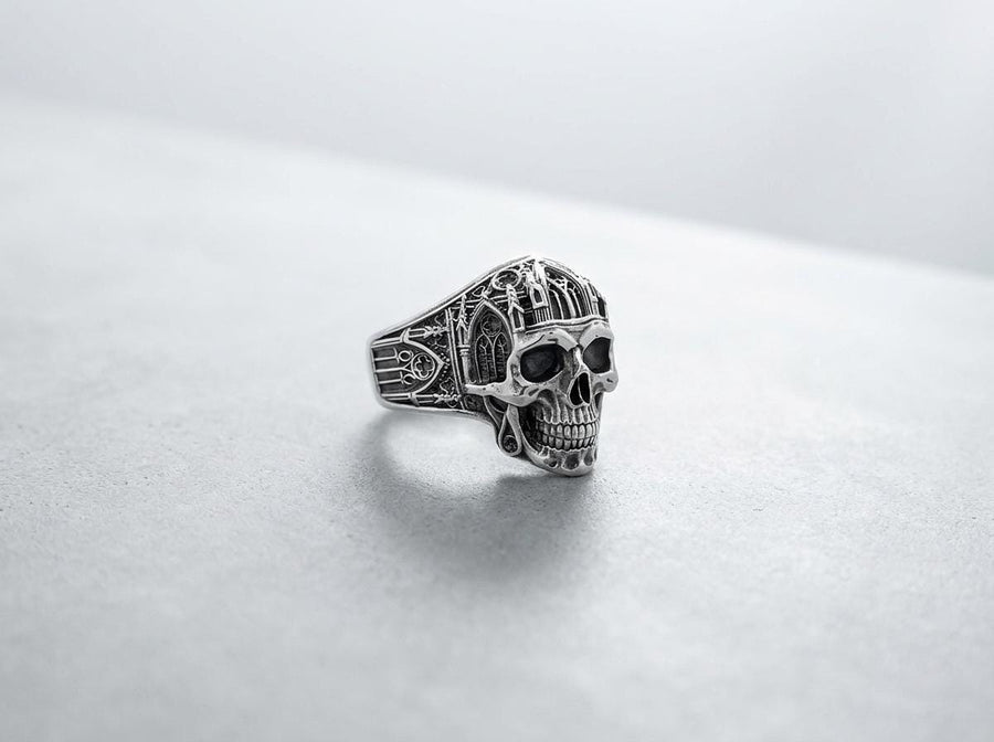 The exceptional micro-casting and silversmithing techniques used to construct this wearable sculpture are evident in its staggering detail. The relief work perfectly captures the delicate mullions of the stained glass windows alongside the anatomical jawline of the skull. The ring features a substantial thickness, with smooth inner bands polished flat to ensure a comfortable, everyday fit suitable for lifelong wear.