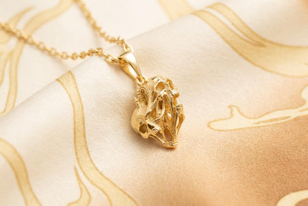 Reimagined in opulent 18k solid yellow gold, this melting skulls pendant transforms into a radiant treasure. The warm tones illuminate the fused faces and elongated bone structures. A subtle matte finish replaces the dark oxidation in the crevices.