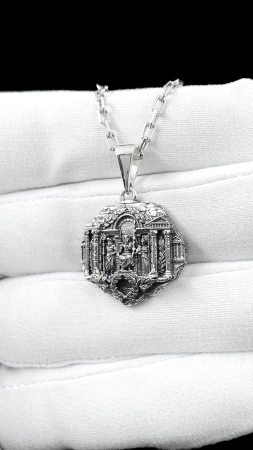 A close-up studio photograph of a 925 sterling silver Greek mythology pendant on a black background. The amulet features a detailed relief of a classical temple housing three figures - Poseidon, Zeus, and Athena. This striking pendant captures the majesty of Mount Olympus. Bright studio lighting illuminates the polished silver gods and temple columns, while pitch-black sulfur oxidation fills the deep crevices between the stone architecture.