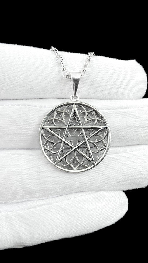 A close-up studio photograph of image_61ba46.png, a circular 925 sterling silver pendant on a black background. The design features a bold, sharp pentagram overlapping an intricate background of openwork gothic cathedral tracery and carved quatrefoil motifs. This striking artisan pendant captures the mesmerizing geometry of medieval architecture. Bright studio lighting illuminates the highly polished lines of the silver five-pointed star, contras