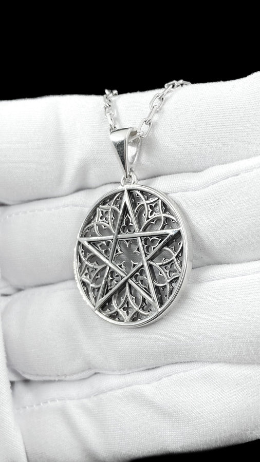 A close-up studio photograph of image_61ba46.png, a circular 925 sterling silver pendant on a black background. The design features a bold, sharp pentagram overlapping an intricate background of openwork gothic cathedral tracery and carved quatrefoil motifs. This striking artisan pendant captures the mesmerizing geometry of medieval architecture. Bright studio lighting illuminates the highly polished lines of the silver five-pointed star, contras