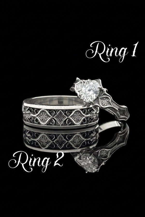 A close-up studio photograph of a matching 925 sterling silver gothic wedding ring set on a grey surface. The wide mens band and the delicate womens engagement ring both feature intricate medieval tracery and carved quatrefoils - highlighted by a dark oxidized background. This striking artisan bridal set perfectly captures the monumental scale of medieval architecture. Bright lighting illuminates the polished silver edges and the sparkling oval g