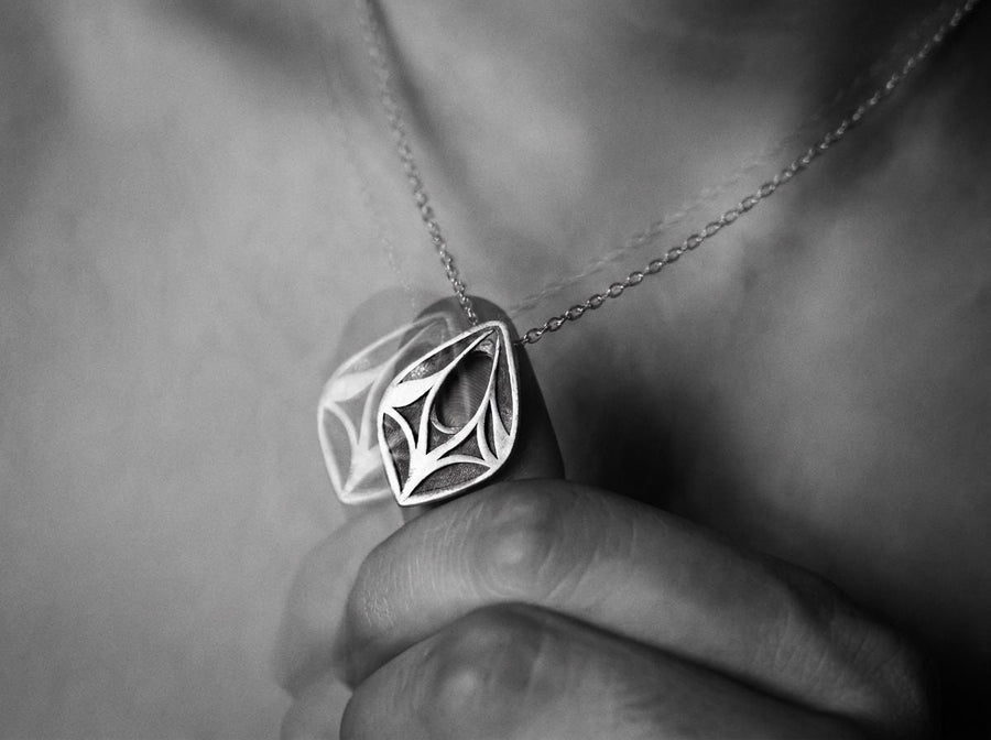 Embrace the mystery of ancient realms with this solid 925 sterling silver abstract eye pendant. Inspired by the watchful spirits of forgotten woodlands and the sleek lines of organic armor, this avant-garde piece seamlessly frames an elegant openwork void within a symmetrical almond silhouette.