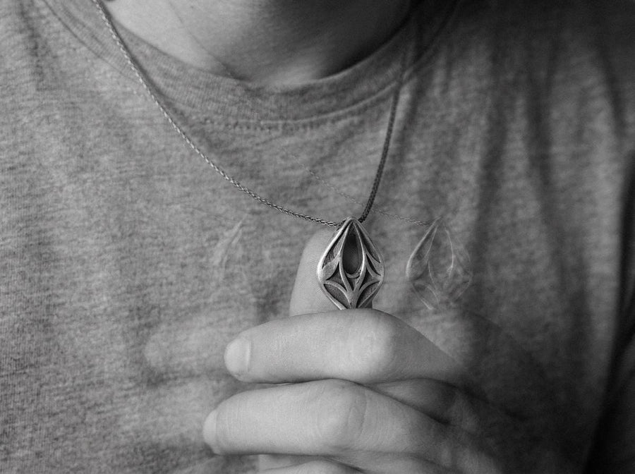 Embrace the mystery of ancient realms with this solid 925 sterling silver abstract eye pendant. Inspired by the watchful spirits of forgotten woodlands and the sleek lines of organic armor, this avant-garde piece seamlessly frames an elegant openwork void within a symmetrical almond silhouette.