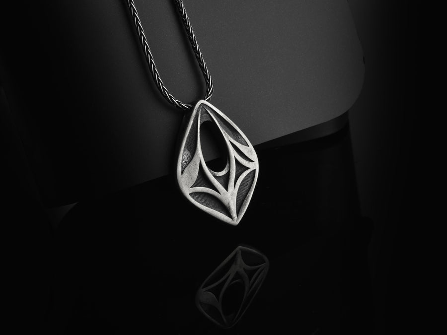 Embrace the mystery of ancient realms with this solid 925 sterling silver abstract eye pendant. Inspired by the watchful spirits of forgotten woodlands and the sleek lines of organic armor, this avant-garde piece seamlessly frames an elegant openwork void within a symmetrical almond silhouette.