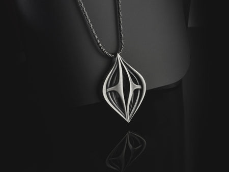 Atmospheric shot of a solid sterling silver alien artifact necklace, featuring sweeping organic geometric arches.
