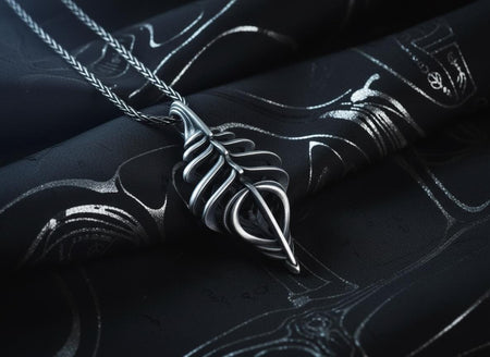 Dark sci-fi silver spine pendant held in a man's hands, showcasing the 3D biomechanical ribcage design.