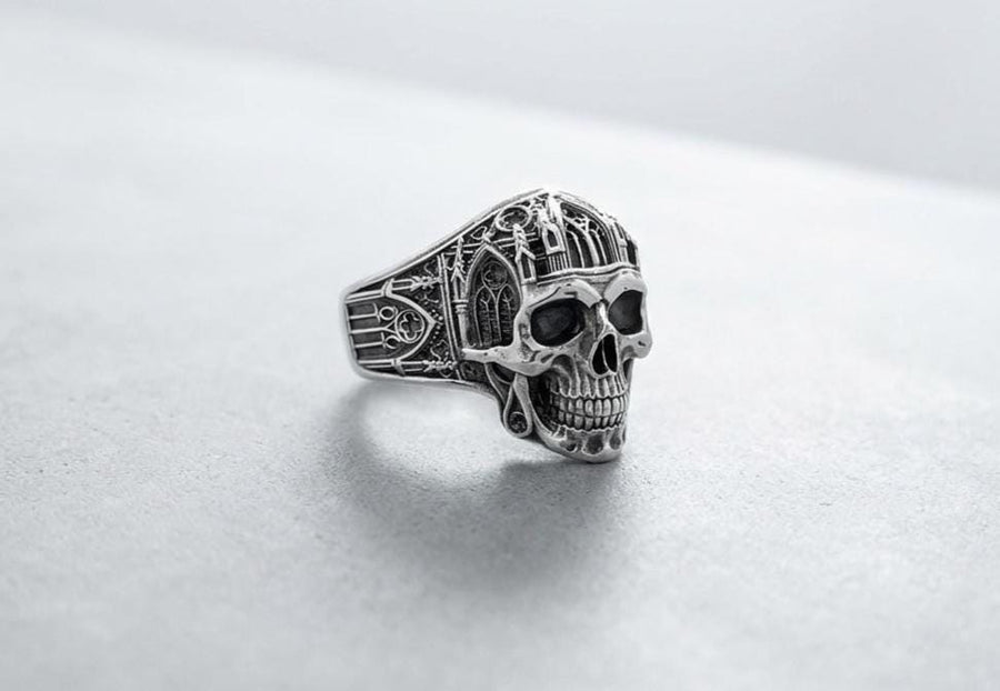 The exceptional micro-casting and silversmithing techniques used to construct this wearable sculpture are evident in its staggering detail. The relief work perfectly captures the delicate mullions of the stained glass windows alongside the anatomical jawline of the skull. The ring features a substantial thickness, with smooth inner bands polished flat to ensure a comfortable, everyday fit suitable for lifelong wear.