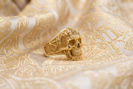 Reimagined in opulent 18k solid yellow gold, this gothic architecture skull ring transforms from a dark silver artifact into a radiant, sunlit treasure. The warm, buttery tones of the gold illuminate the intricate cathedral spires and lancet windows. Instead of dark oxidation, a subtle matte brushed finish rests in the recessed architectural alcoves, allowing the highly polished skull and arches to gleam with a luxurious, classic luster.