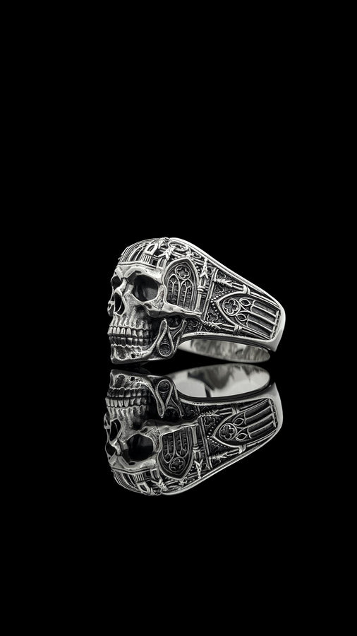 The exceptional micro-casting and silversmithing techniques used to construct this wearable sculpture are evident in its staggering detail. The relief work perfectly captures the delicate mullions of the stained glass windows alongside the anatomical jawline of the skull. The ring features a substantial thickness, with smooth inner bands polished flat to ensure a comfortable, everyday fit suitable for lifelong wear.
