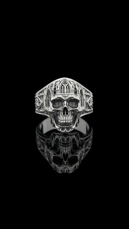 The exceptional micro-casting and silversmithing techniques used to construct this wearable sculpture are evident in its staggering detail. The relief work perfectly captures the delicate mullions of the stained glass windows alongside the anatomical jawline of the skull. The ring features a substantial thickness, with smooth inner bands polished flat to ensure a comfortable, everyday fit suitable for lifelong wear.