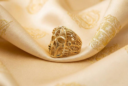 Reimagined in opulent 18k solid yellow gold, this gothic architecture skull ring transforms into a radiant treasure. The warm tones illuminate the skeletal hands, cathedral arches, and side crosses. Instead of dark oxidation, a subtle matte brushed finish rests in the recessed alcoves, allowing the highly polished skull and architectural details to gleam with a luxurious, classic luster.
