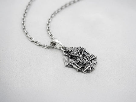 A close-up studio photograph of a 925 sterling silver Egyptian pendant on a solid black background. The rectangular amulet features a detailed relief of an Egyptian queen holding a bow, set against a backdrop of pyramids and temple columns. This striking pendant captures the mystique of ancient Egypt. Bright studio lighting illuminates the polished silver queen and Anubis figure at the base, while pitch-black sulfur oxidation fills the deep crevi