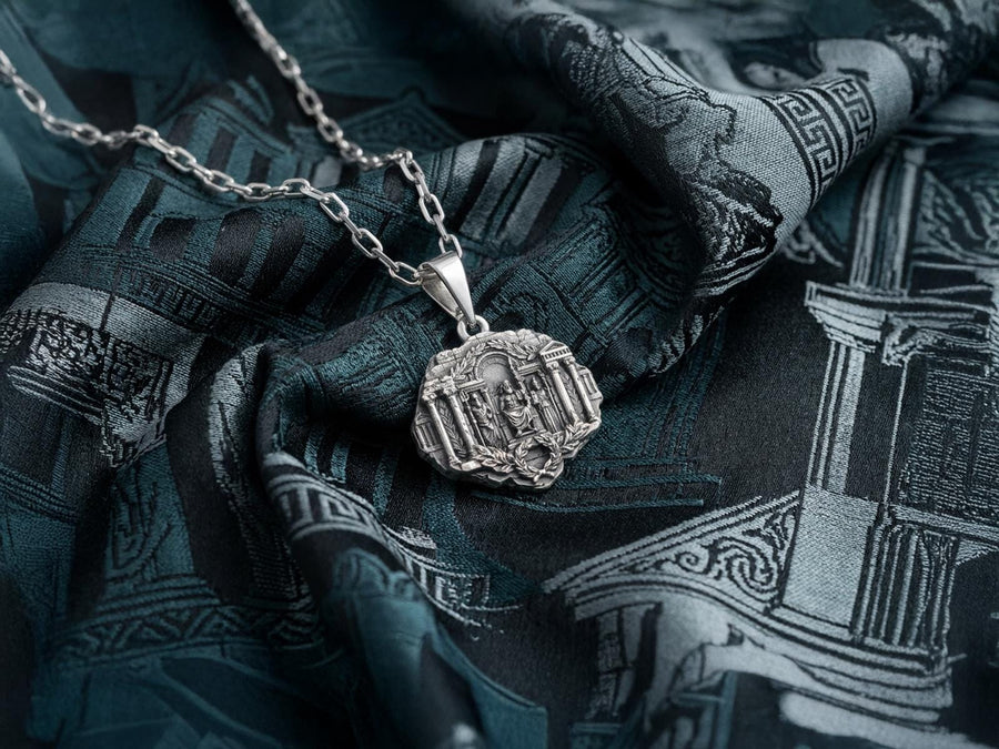 A close-up studio photograph of a 925 sterling silver Greek mythology pendant on a black background. The amulet features a detailed relief of a classical temple housing three figures - Poseidon, Zeus, and Athena. This striking pendant captures the majesty of Mount Olympus. Bright studio lighting illuminates the polished silver gods and temple columns, while pitch-black sulfur oxidation fills the deep crevices between the stone architecture.