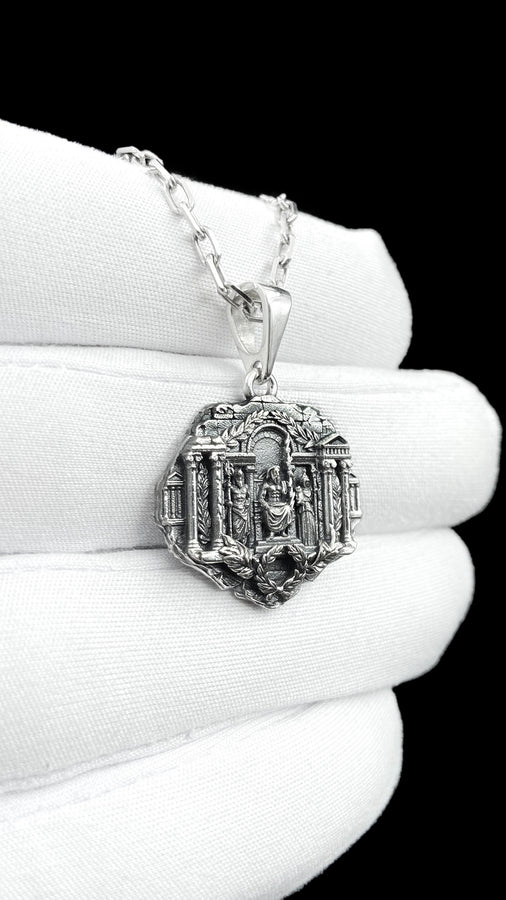 A close-up studio photograph of a 925 sterling silver Greek mythology pendant on a black background. The amulet features a detailed relief of a classical temple housing three figures - Poseidon, Zeus, and Athena. This striking pendant captures the majesty of Mount Olympus. Bright studio lighting illuminates the polished silver gods and temple columns, while pitch-black sulfur oxidation fills the deep crevices between the stone architecture.
