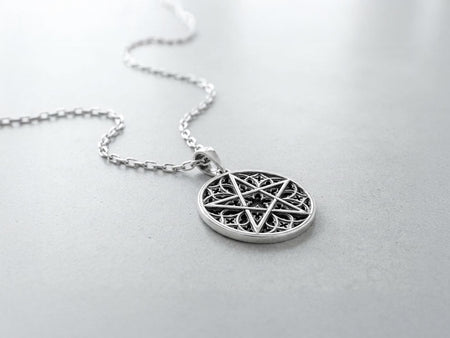 A close-up studio photograph of image_61ba46.png, a circular 925 sterling silver pendant on a black background. The design features a bold, sharp pentagram overlapping an intricate background of openwork gothic cathedral tracery and carved quatrefoil motifs. This striking artisan pendant captures the mesmerizing geometry of medieval architecture. Bright studio lighting illuminates the highly polished lines of the silver five-pointed star, contras