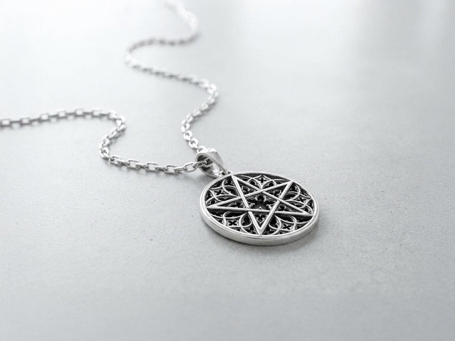 A close-up studio photograph of image_61ba46.png, a circular 925 sterling silver pendant on a black background. The design features a bold, sharp pentagram overlapping an intricate background of openwork gothic cathedral tracery and carved quatrefoil motifs. This striking artisan pendant captures the mesmerizing geometry of medieval architecture. Bright studio lighting illuminates the highly polished lines of the silver five-pointed star, contras