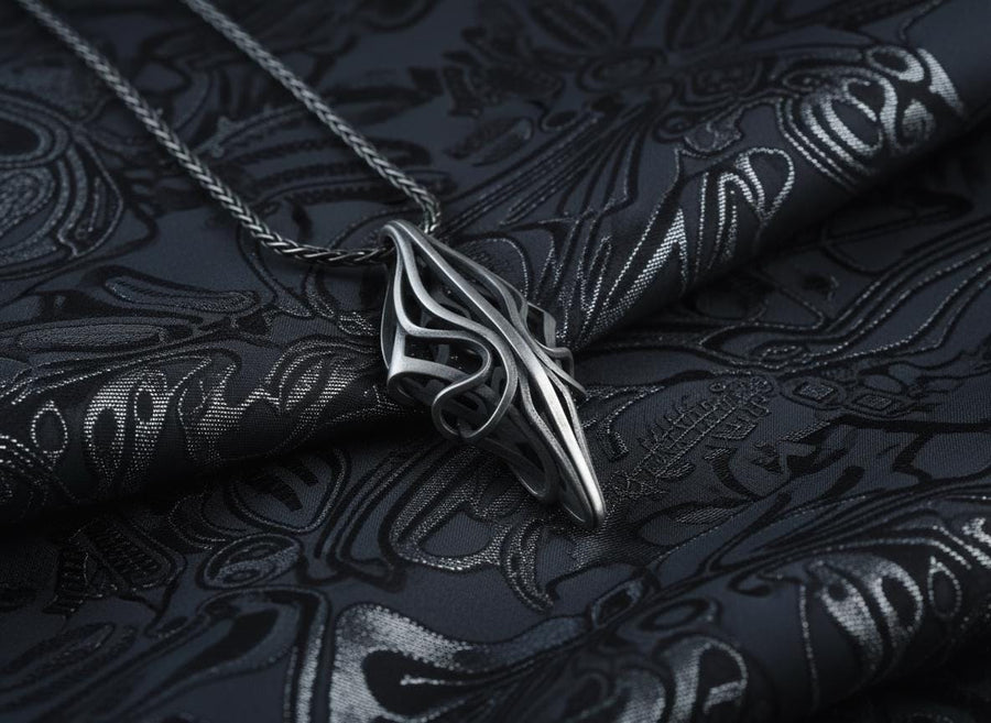 Choose between an Anchor or Foxtail chain to complete your look. Heavy oxidation settles into the textured inner curves, giving this openwork geometric pendant a shadowed, minimalist character.Exceptional silversmithing is evident in this oxidized silver avant-garde necklace. The relief work perfectly balances the sharp structural points with smooth, sweeping interlaced inner curves. A bold modern statement piece for alternative jewelry collector