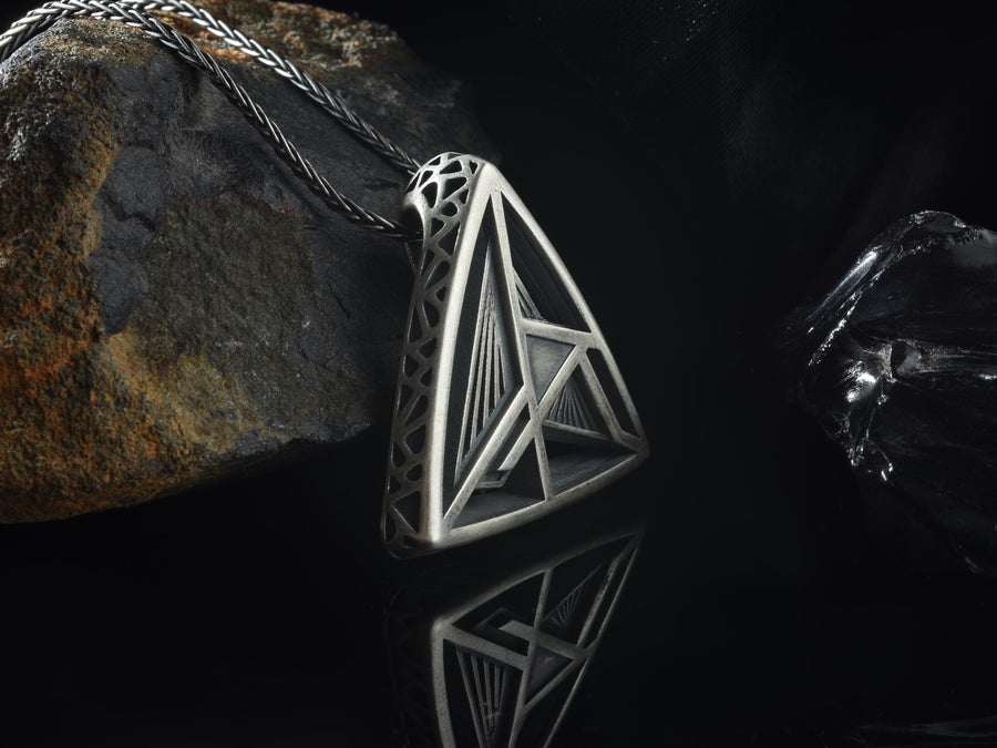 Embrace the structural elegance of modern ruins and sacred geometry. This architectural silver triangle pendant is a bold statement piece, designed for those who find beauty in precise lines and open space. Crafted from 925 sterling silver, the necklace features a complex, three-dimensional geometric framework that creates a captivating optical depth, making it a true centerpiece of alternative jewelry. The avant-garde triangular design features