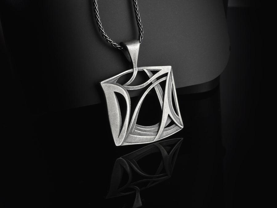 Inspired by the concept of architectural portals and the chaotic grace of natural elements, this amulet feels like a relic of an advanced civilization. The design masterfully balances a structured outer frame with sweeping, wind-like internal curves, creating a dynamic visual rhythm. It is a modern dark artifact that grounds your spirit while elevating your everyday aesthetic.