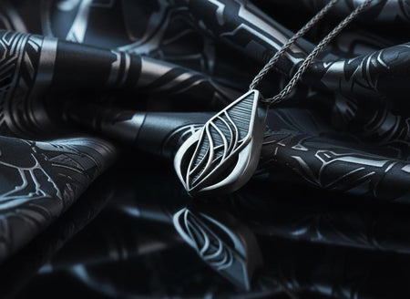 Embrace the fluid elegance of dark fantasy and organic architecture. This sweeping silver teardrop pendant is a striking statement piece, designed for those who are captivated by the seamless blend of natural forms and futuristic biomechanics. Crafted from solid 925 sterling silver, this amulet offers a sophisticated touch of avant-garde mystique to any alternative look. A close-up studio photograph of a 925 sterling silver sci-fi pendant resting