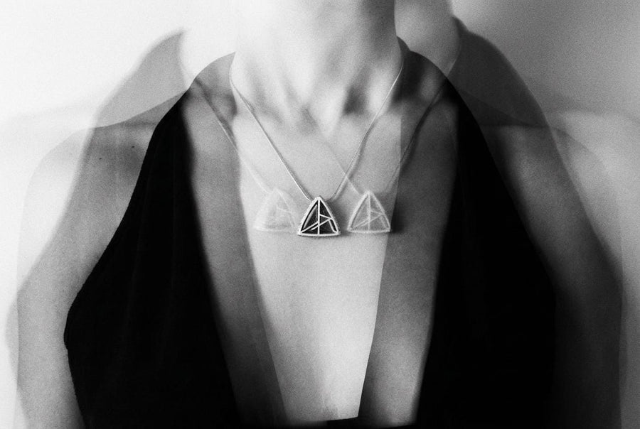 Embrace the structural elegance of modern ruins and sacred geometry. This architectural silver triangle pendant is a bold statement piece, designed for those who find beauty in precise lines and open space. Crafted from 925 sterling silver, the necklace features a complex, three-dimensional geometric framework that creates a captivating optical depth, making it a true centerpiece of alternative jewelry. The avant-garde triangular design features