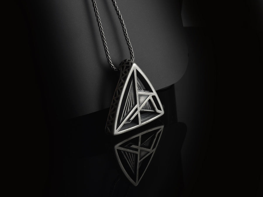 Embrace the structural elegance of modern ruins and sacred geometry. This architectural silver triangle pendant is a bold statement piece, designed for those who find beauty in precise lines and open space. Crafted from 925 sterling silver, the necklace features a complex, three-dimensional geometric framework that creates a captivating optical depth, making it a true centerpiece of alternative jewelry. The avant-garde triangular design features