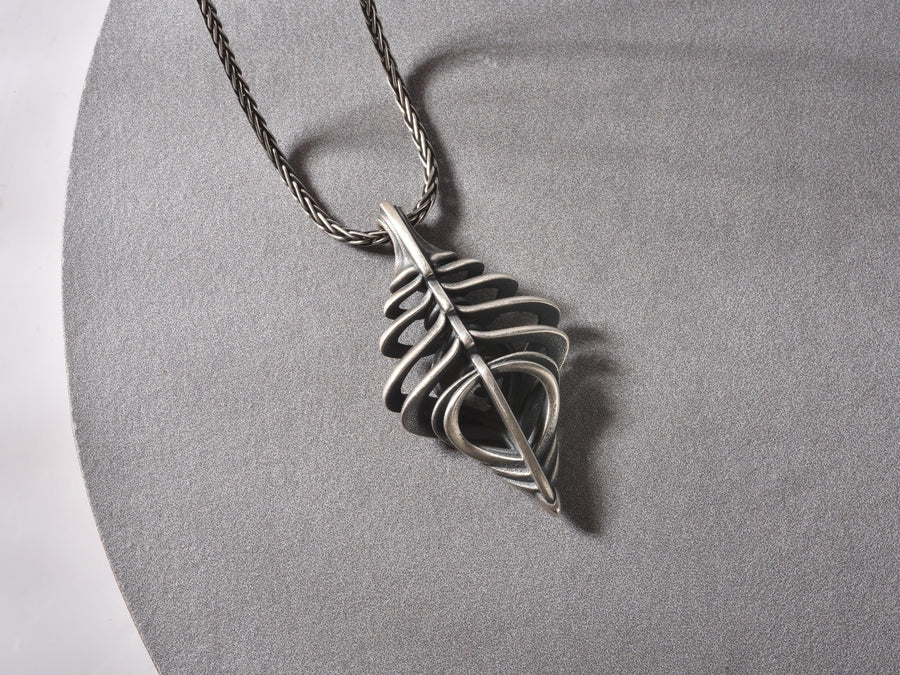 Avant-garde dark fantasy jewelry piece: a striking 3D skeletal silver drop charm hanging from an anchor chain.