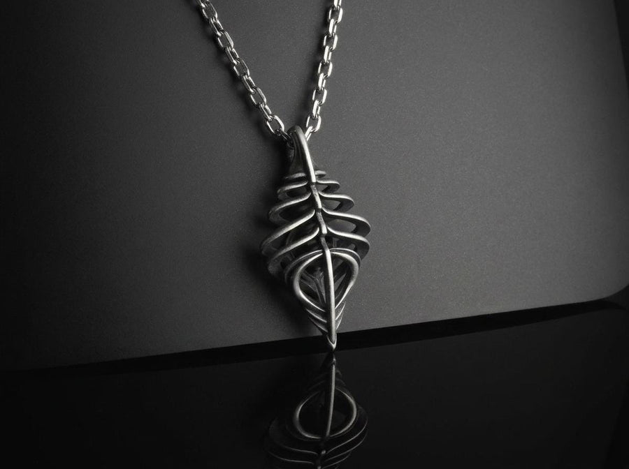 Avant-garde dark fantasy jewelry piece: a striking 3D skeletal silver drop charm hanging from an anchor chain.
