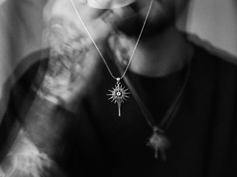 Man wearing a geometric dark fantasy starburst pendant on a silver chain against a black shirt. Celestial Star Silver Pendant for Men, Fantasy Compass Necklace, Gothic Sunburst Amulet, Sci-Fi Artifact, Oxidized Silver Navigator Jewelry