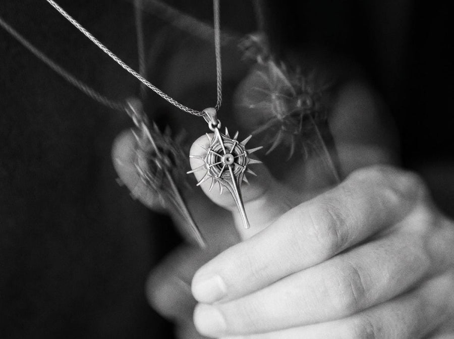 Man wearing a geometric dark fantasy starburst pendant on a silver chain against a black shirt. Celestial Star Silver Pendant for Men, Fantasy Compass Necklace, Gothic Sunburst Amulet, Sci-Fi Artifact, Oxidized Silver Navigator Jewelry