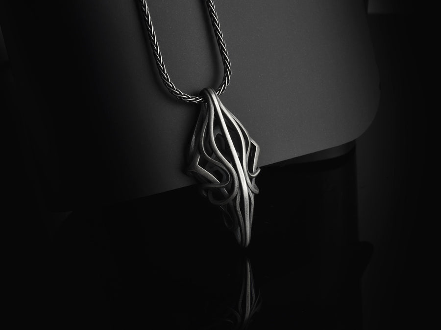 Choose between an Anchor or Foxtail chain to complete your look. Heavy oxidation settles into the textured inner curves, giving this openwork geometric pendant a shadowed, minimalist character.Exceptional silversmithing is evident in this oxidized silver avant-garde necklace. The relief work perfectly balances the sharp structural points with smooth, sweeping interlaced inner curves. A bold modern statement piece for alternative jewelry collector