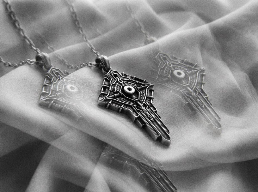 Solid 925 Sterling Silver with deep oxidized finish for architectural depth. Choose between Anchor or Foxtail chain to complete your look. Perfectly complements techwear styles with precise geometric lines. A close-up studio photograph of a 925 sterling silver robotic cross pendant resting on a dark reflective surface. The avant-garde design features mechanical circuitry pathways forming a cybernetic crucifix, highlighted by a dark matte oxidized